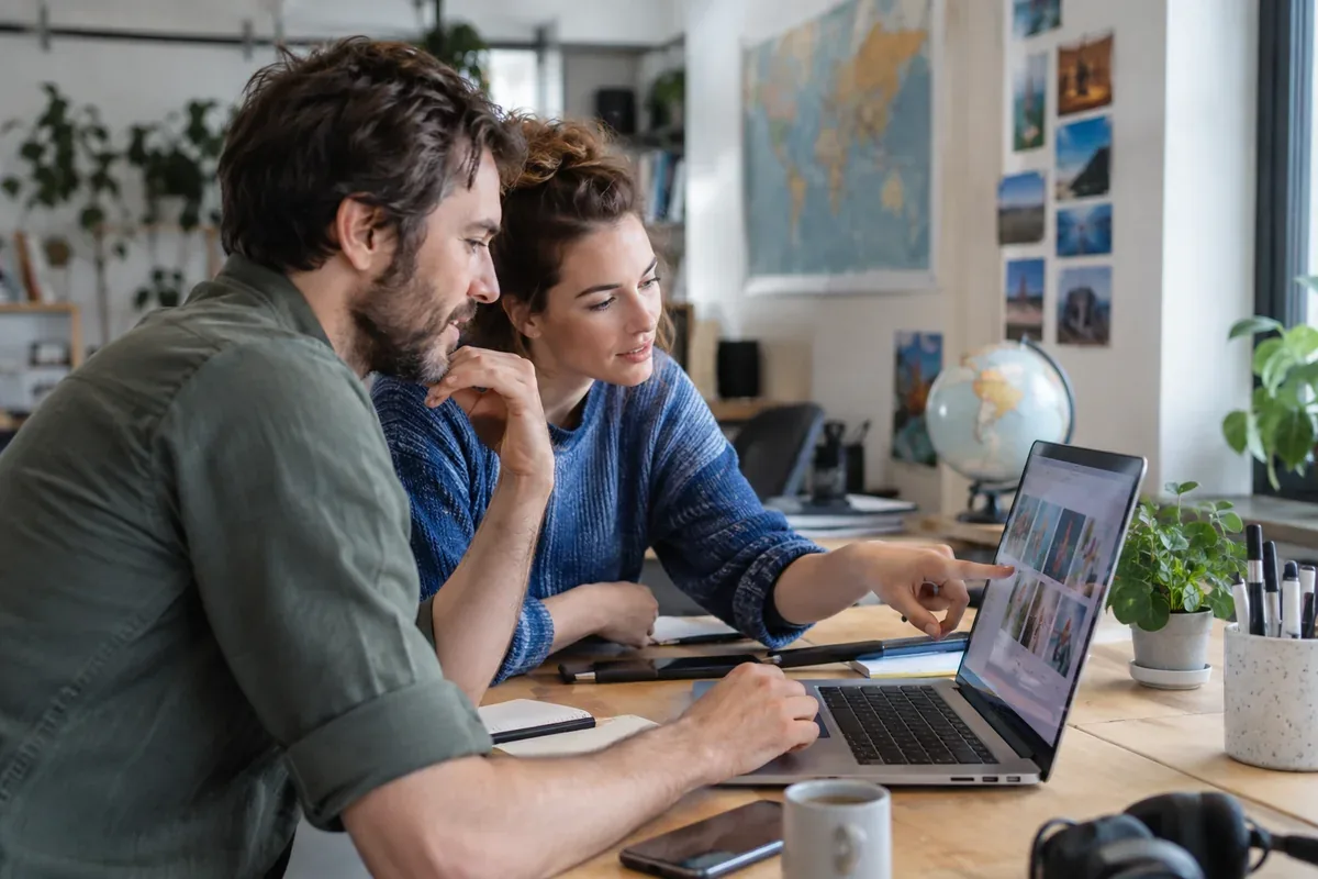 Two people examine a computer screen together
