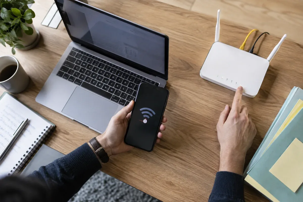 A person compares a Wi-Fi connection in two rooms near a home router